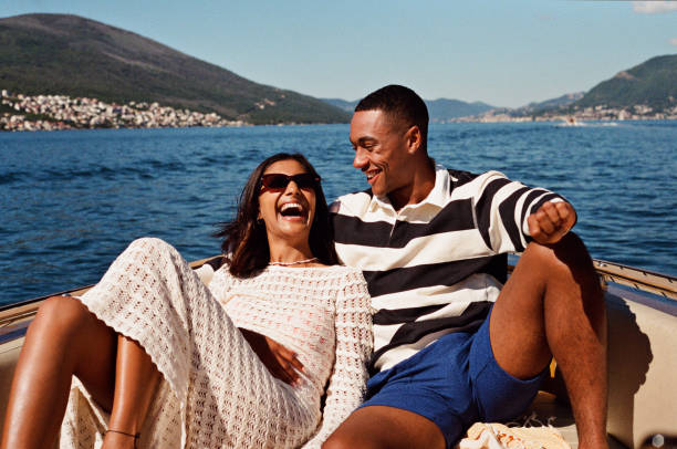 woman laughing with boyfriend in speedboat - travel stock pictures, royalty-free photos & images