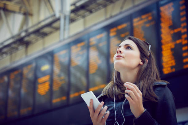 woman looking at departure information, london, uk - travel stock pictures, royalty-free photos & images