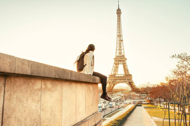 woman looking at the eiffel tower in paris - travel stock pictures, royalty-free photos & images
