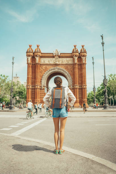 woman looking at triumphal arch in barcelona - travel stock pictures, royalty-free photos & images