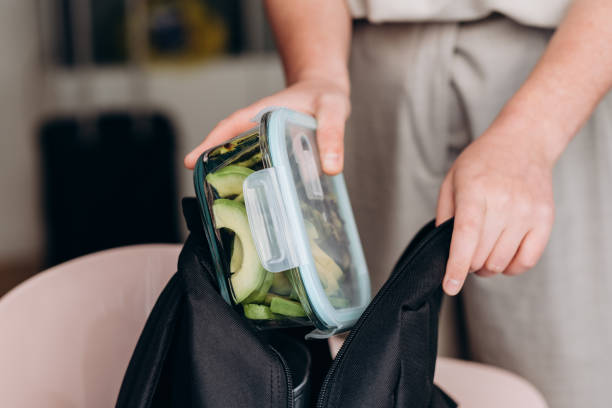 woman makes a healthy lunch at the lunch box zucchini pancakes and avocado salad , healthy lunch to go - junk food stock pictures, royalty-free photos & images