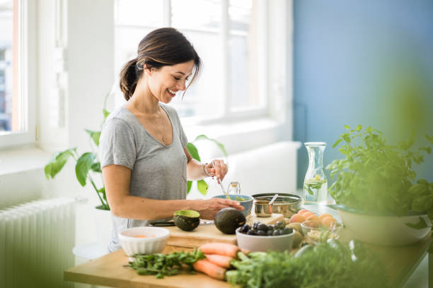 woman preparing healthy food in her kitchen - food stock pictures, royalty-free photos & images