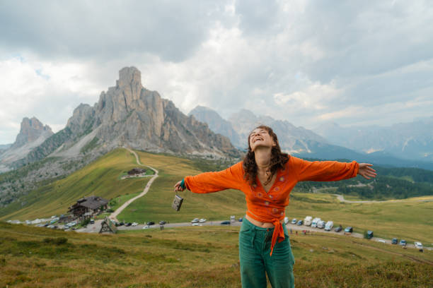 woman raising arms in awe on the background of passo giau in dolomites - travel photos et images de collection