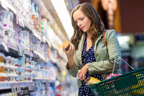 woman reading food labels at grocery store - food stock pictures, royalty-free photos & images