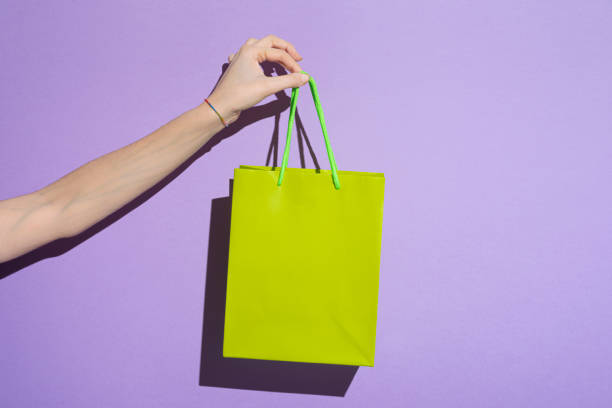 woman's hand carrying colorful shopping bag - fashion stock pictures, royalty-free photos & images