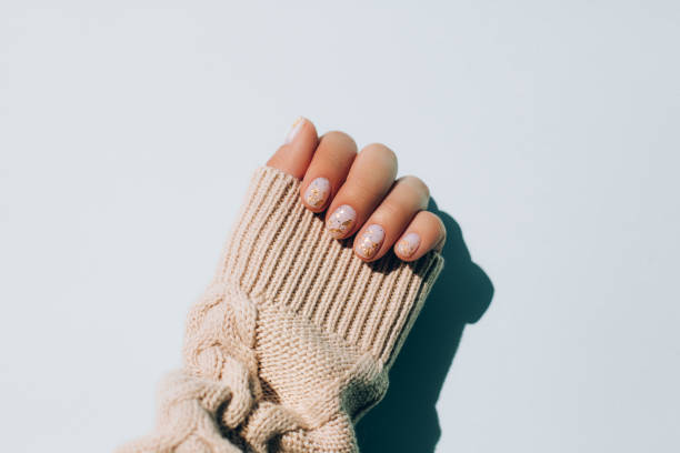 woman's hand in warm sweater showing manicure - nails art stock pictures, royalty-free photos & images