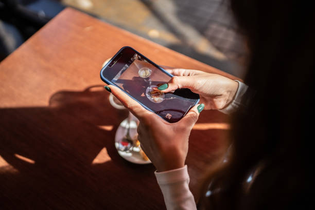 woman's hand photographing her fodd and drink in a cafeteria - food stock pictures, royalty-free photos & images