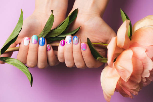 woman's hands with bright manicure holding peony flower - nails art stock pictures, royalty-free photos & images