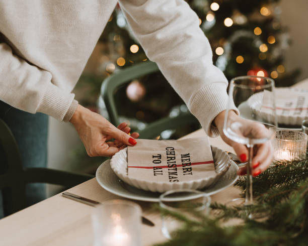 woman setting the christmas table preparing for dinner party - home decoration stock pictures, royalty-free photos & images