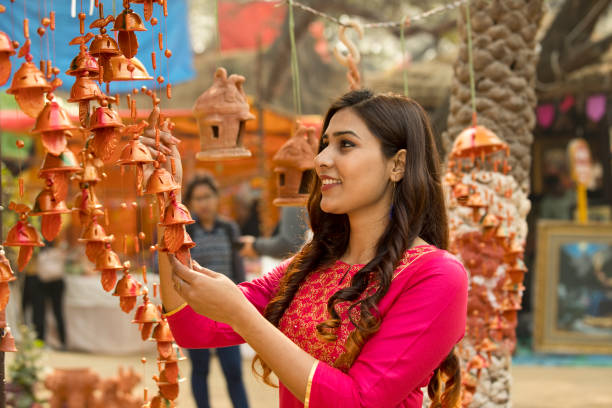 woman shopping for wall hanging at street market - home decoration stock pictures, royalty-free photos & images