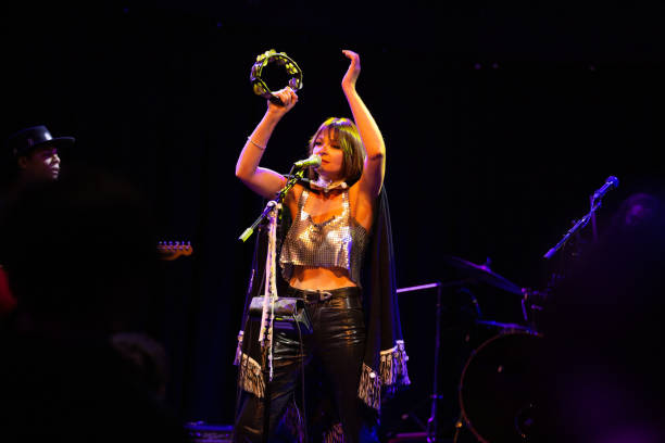 woman singing onstage with band - concert stock pictures, royalty-free photos & images