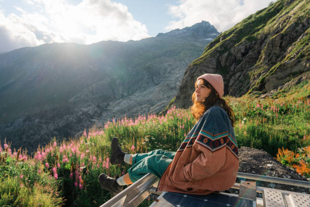 woman sitting on rooftop of camper van overlooking furka pass - travel stock pictures, royalty-free photos & images