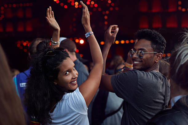 woman smiling to camera at concert - concert stock pictures, royalty-free photos & images
