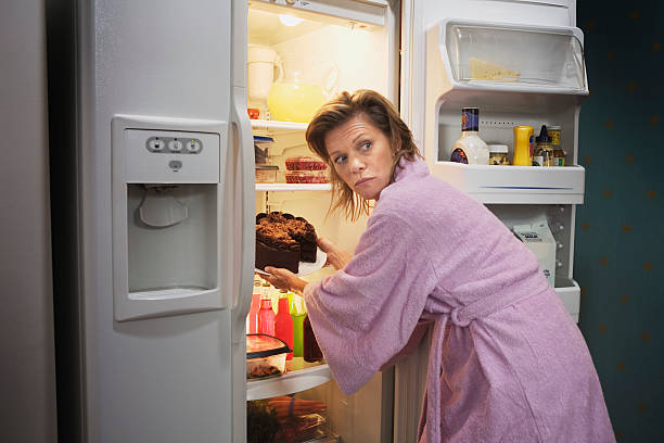 woman taking cake out of refrigerator - junk food stock pictures, royalty-free photos & images