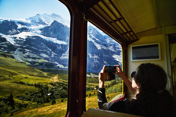 woman taking photo with smartphone of jungfrau while riding in train - travel stock pictures, royalty-free photos & images