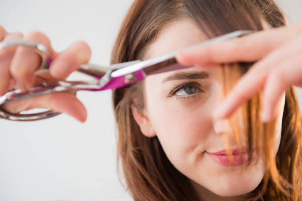 woman trimming her bangs - hairstyle stock pictures, royalty-free photos & images
