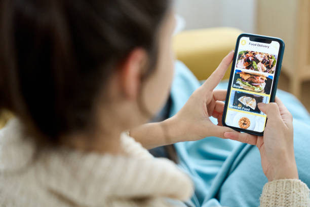 woman using a food delivery app on her mobile phone. - food stock pictures, royalty-free photos & images