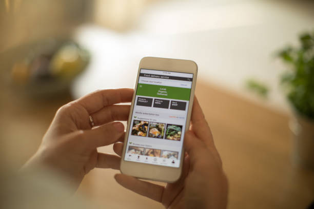 woman using meal delivery service through mobile app. - food stock pictures, royalty-free photos & images