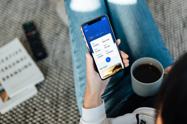 woman using smartphone to book flight tickets and plan holiday - travel stock pictures, royalty-free photos & images