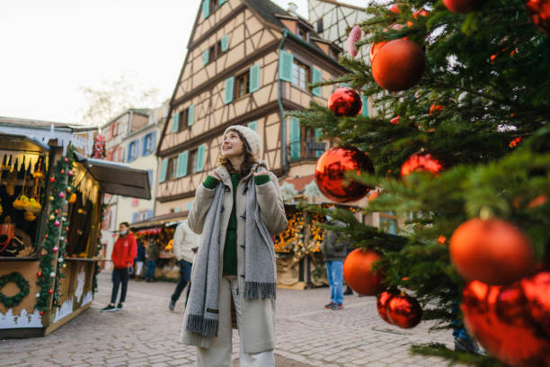 woman walking near the christmas tree in city centre - travel stock pictures, royalty-free photos & images