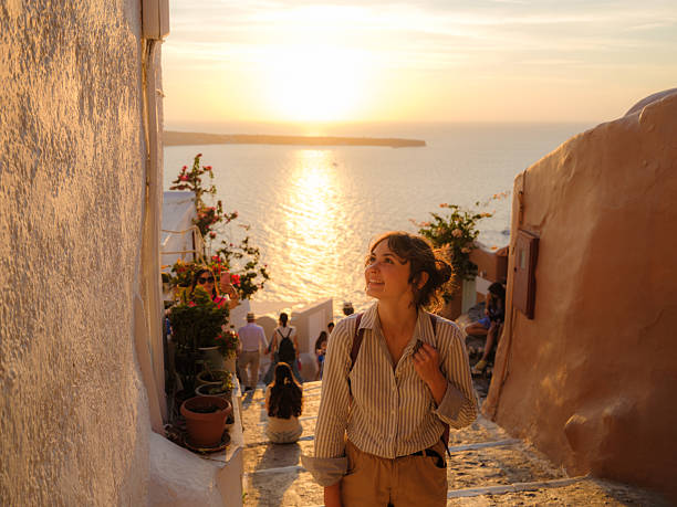 woman walking on streets on santorini island at sunset - travel stock pictures, royalty-free photos & images