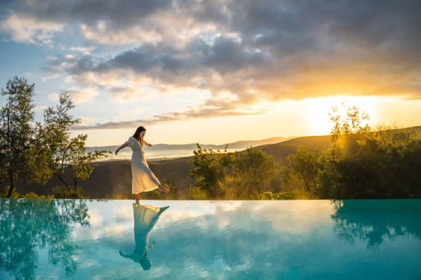 woman walking on the edge of infinity pool - travel stock pictures, royalty-free photos & images