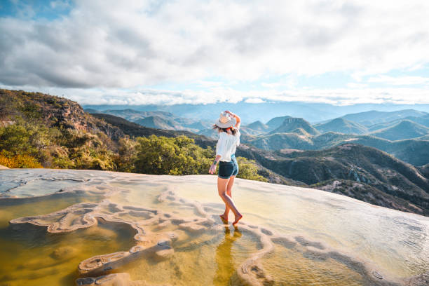 woman walking on the limestone rock formations at hierve el agua, oaxaca, mexico - travel stock pictures, royalty-free photos & images