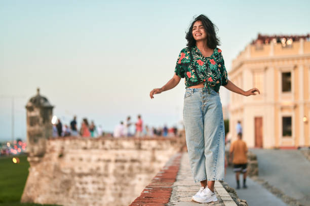 woman walking on wall in cartagena, colombia - fashion stock pictures, royalty-free photos & images
