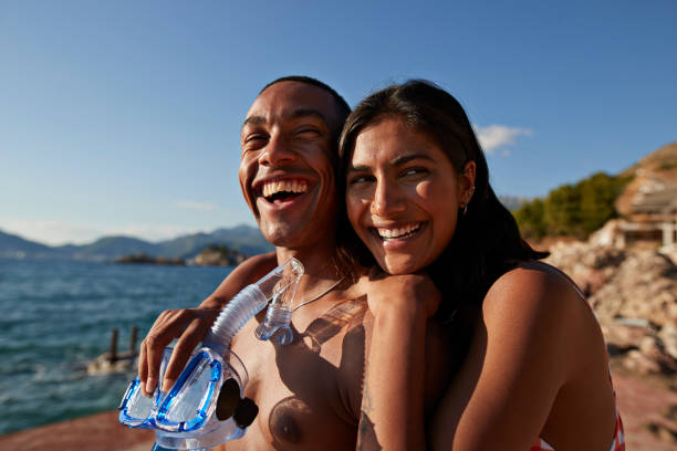 woman with boyfriend holding snorkel and scuba mask - travel stock pictures, royalty-free photos & images