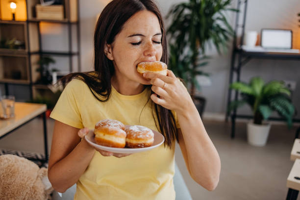 woman with donuts - junk food stock pictures, royalty-free photos & images