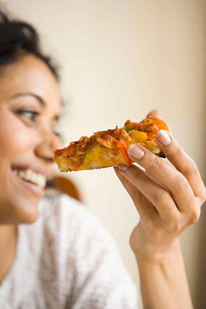 woman with slice of pizza - junk food stockfoto's en -beelden