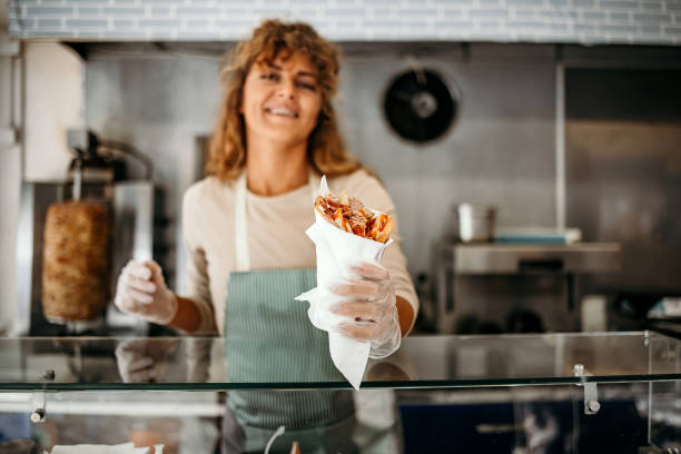 woman works in a fast food shop - junk food stock pictures, royalty-free photos & images