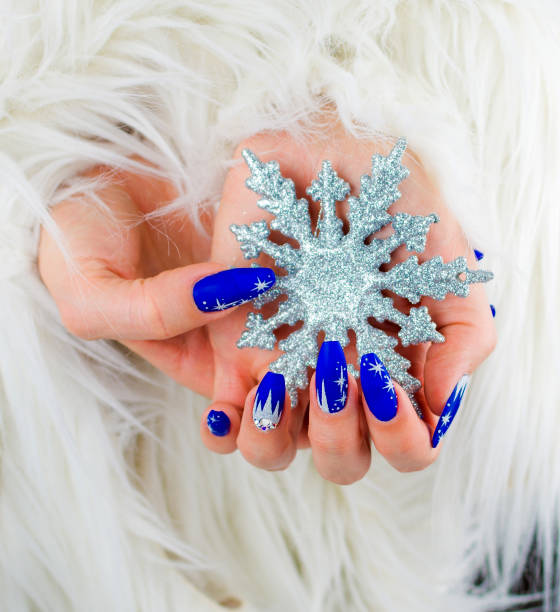 womans hands with nail art holding a christmas snowflake decoration - nails art stock pictures, royalty-free photos & images
