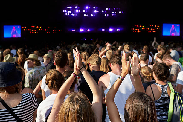 women clapping hands at large concert - concert stock pictures, royalty-free photos & images