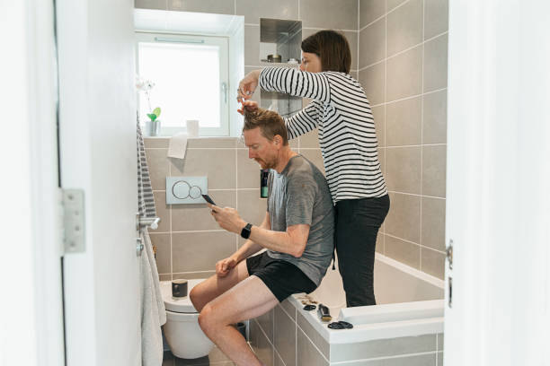 women cutting partner's hair in the bathroom - hairstyle stock pictures, royalty-free photos & images