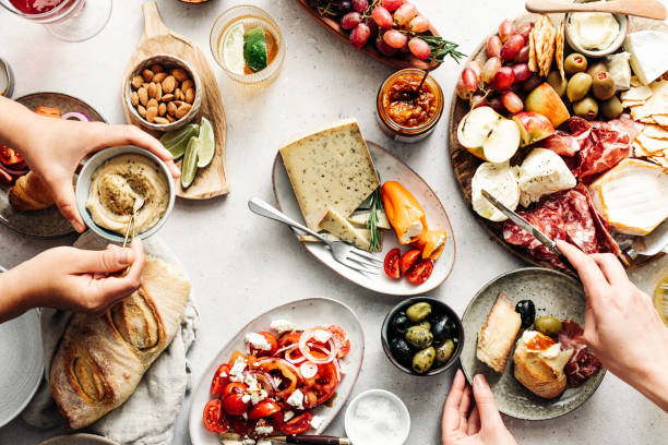 women eating fresh mediterranean platter on table - food stock pictures, royalty-free photos & images