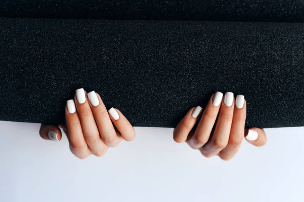 women's hands with white manicure on a black and white background. manicurist. nail care. nail polish. - nails art stock pictures, royalty-free photos & images