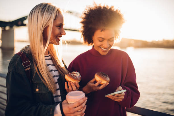 women using phone - junk food stock pictures, royalty-free photos & images