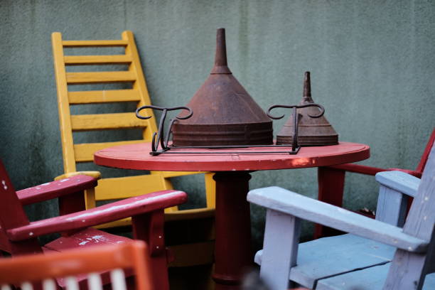 wooden table with vintage chairs and rusty metal funnels - garden decoration stock pictures, royalty-free photos & images