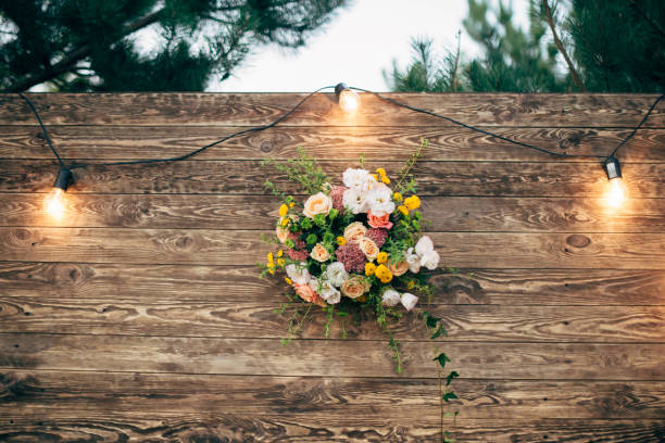 wooden wedding backdrop with light garland and flower arrangement - garden decoration stock pictures, royalty-free photos & images