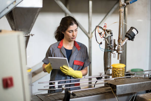 worker woman with tablet revise conveyor belt machine in food factory - food stock pictures, royalty-free photos & images