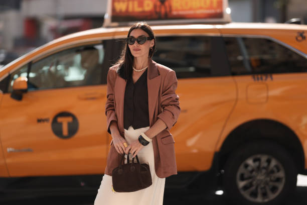 Yana Echko seen wearing YSL brown sunglasses, Bottega Veneta brown leather earrings, white pearl necklace, The Frankie Shop brown pinstripe vest,...
