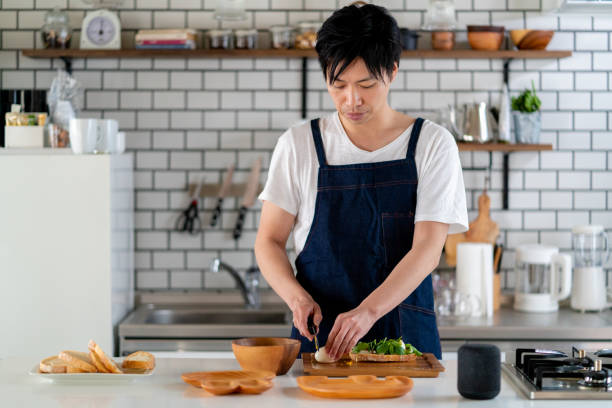 young adult male cooking at home alone - food stock pictures, royalty-free photos & images