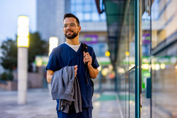 young adult male nurse traveling through the city - travel stock pictures, royalty-free photos & images