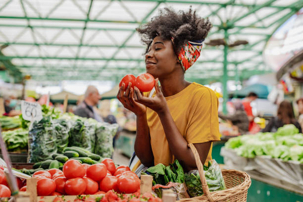 young african woman buying tomatoes at the market - food stock pictures, royalty-free photos & images