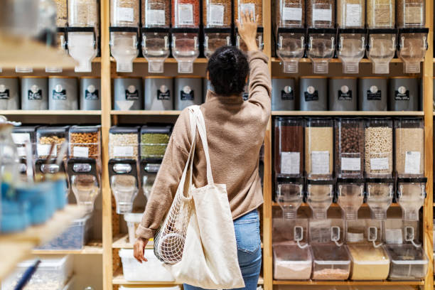 young african woman shopping in zero waste store - food stockfoto's en -beelden