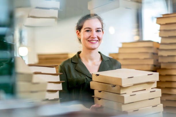 young and female small business owner with pizza boxes - junk food stock pictures, royalty-free photos & images