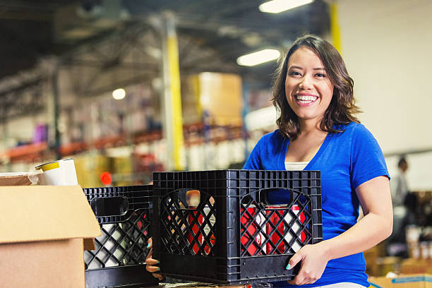 young asian american volunteer working in food bank warehouse - food stock pictures, royalty-free photos & images