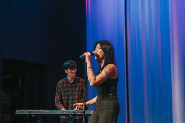 young asian chinese female lead singer and keyboard player live band group performance on stage - concert stock pictures, royalty-free photos & images
