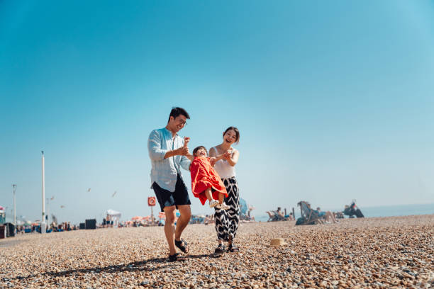 young asian family having fun on the beach - travel stockfoto's en -beelden